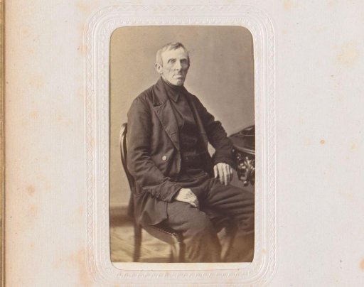 Portrait of a man, seated at a table