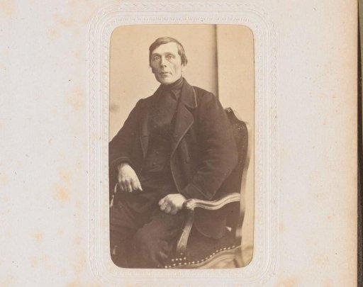 Portrait of a man, seated at a table