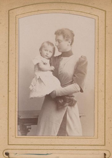 Portrait of a standing woman holding a girl in her arms