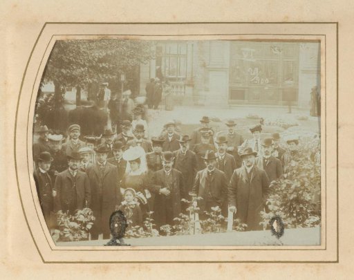 Group portrait of men, women and a child on a square