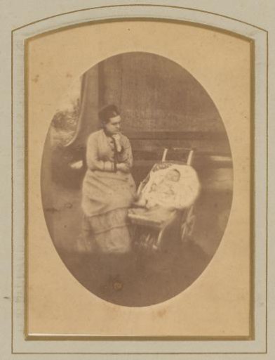 Portrait of a seated woman and a baby in a pram