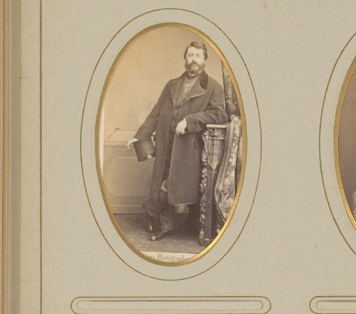 Portrait of a standing man with a hat in his hand, leaning on a balustrade