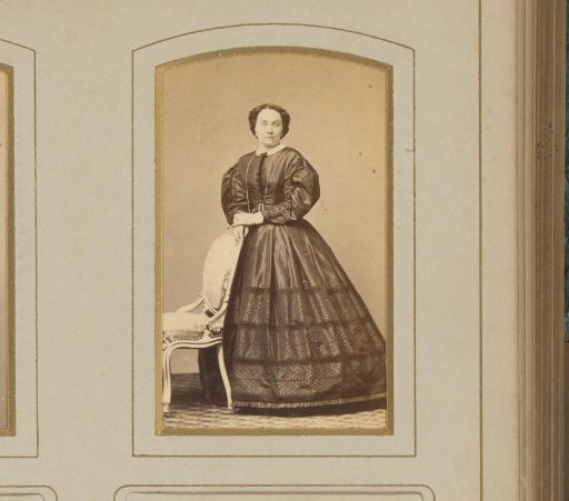 Portrait of a woman standing by a chair