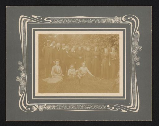 Group portrait with men, women, and children in a garden