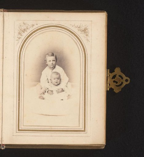 Portrait of a seated boy with a baby