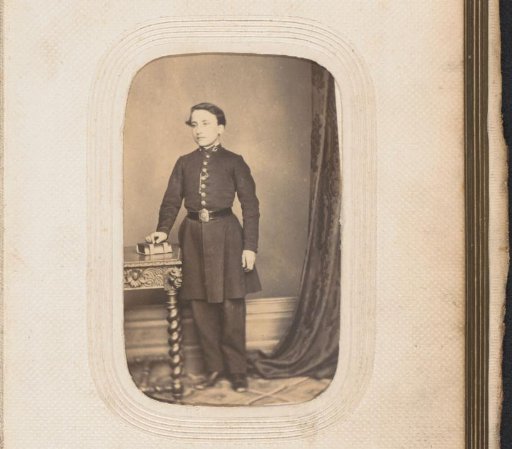 Portrait of a standing boy with an album on a table