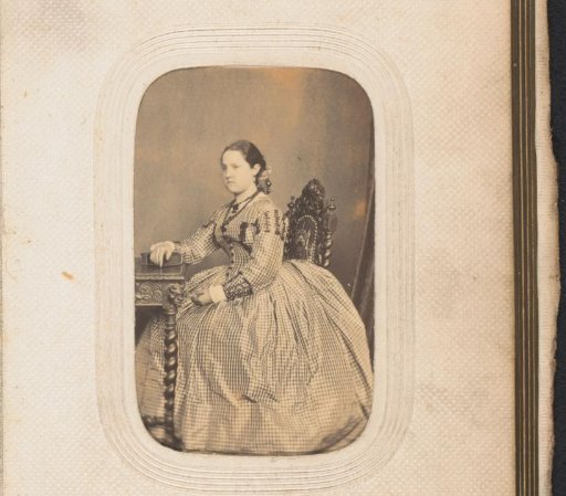 Portrait of a girl, seated at a table with an album