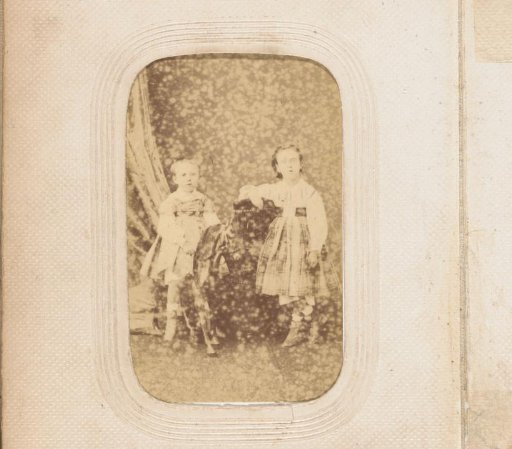 Portrait of a boy on a rocking horse and a standing girl