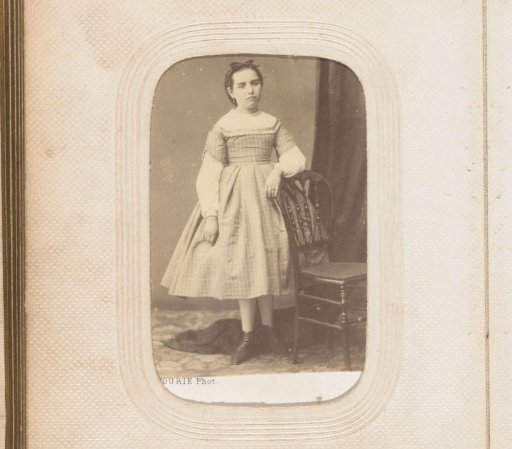 Portrait of a standing girl by a chair