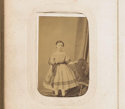 Portrait of a standing girl by a chair