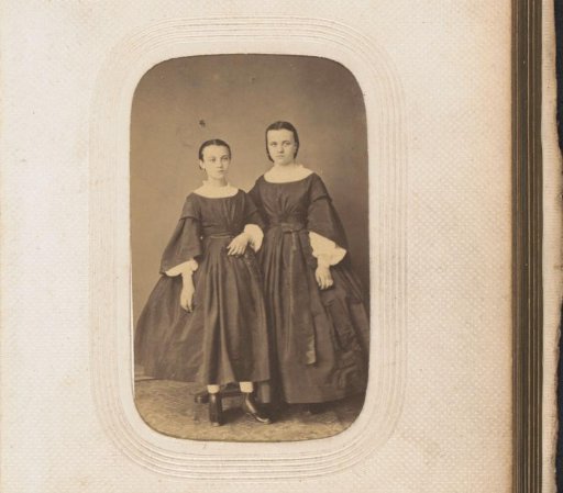Portrait of two standing girls in identical dresses