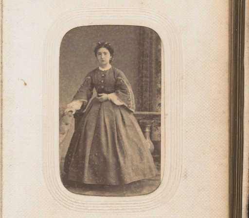 Portrait of a standing young woman by an armchair