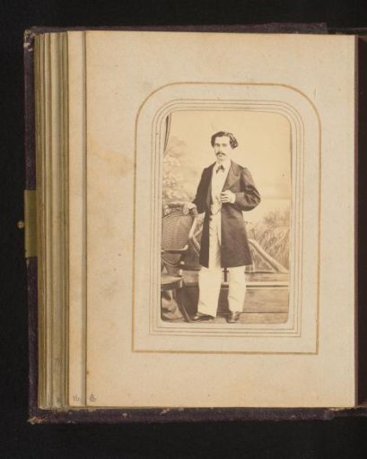 Portrait of a standing man beside a chair