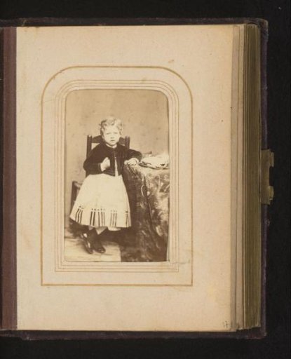 Portrait of a Standing Child at a Table with a Hat