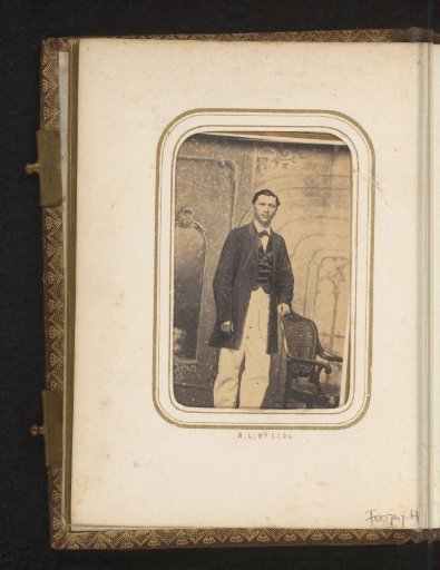 Portrait of a man by a chair