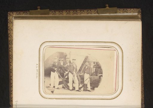 Group portrait of crew members of a ship by a cannon