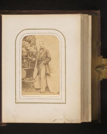 Portrait of a standing man in a garden with garden chairs