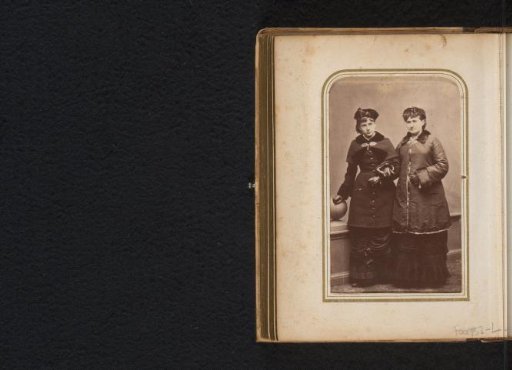 Portrait of two standing women in overcoats by a balustrade