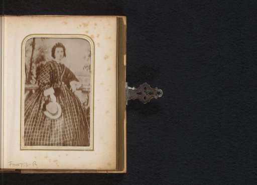 Portrait of a standing woman with a hat in her hand