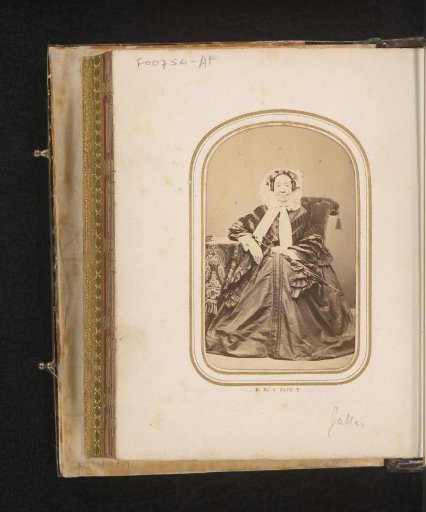 Portrait of an old seated woman with cap and umbrella