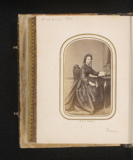 Portrait of a seated woman at a table with a book