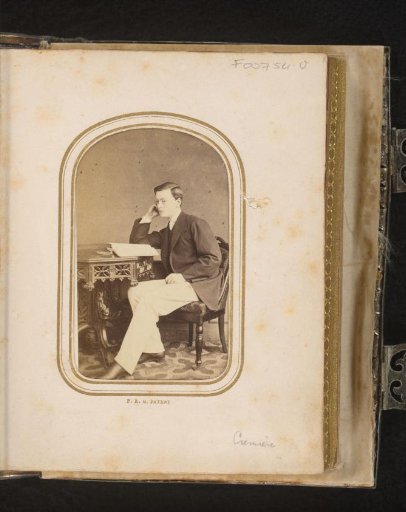Portrait of a young man, seated at a table with books