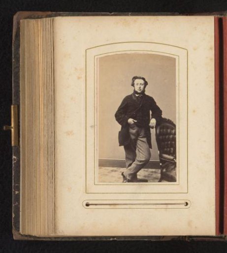 Portrait of a man with a beard by a chair