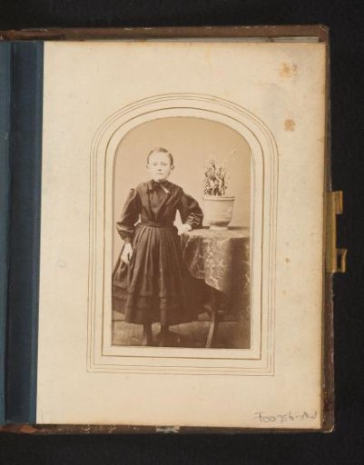 Portrait of a girl, standing by a table with a plant