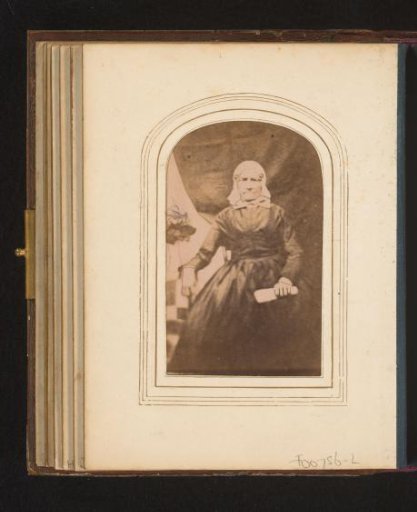 Portrait of a seated woman with a white traditional cap