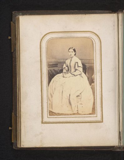 Portrait of a woman, seated at a table with books