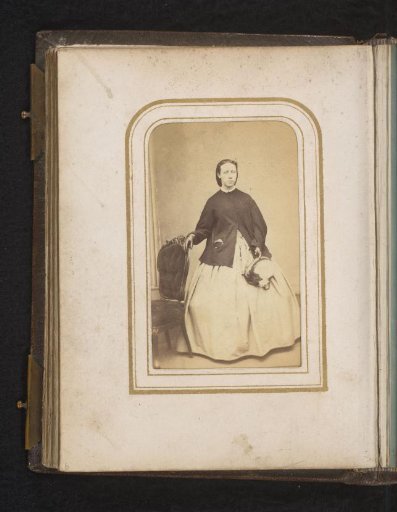 Portrait of a woman, standing by a chair