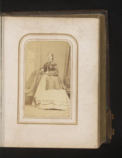 Portrait of a woman, standing by a chair