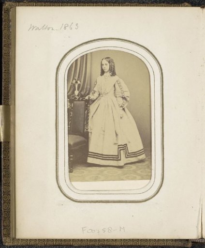 Portrait of a young woman with ringlets in a long dress