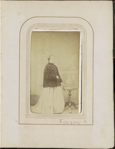 Portrait of a woman in a fur cloak at a table