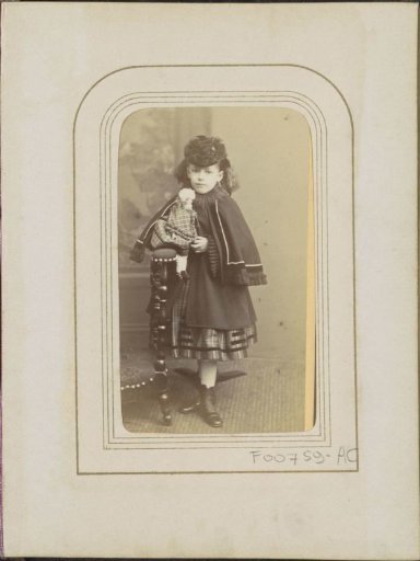Portrait of a girl in a cape with a doll