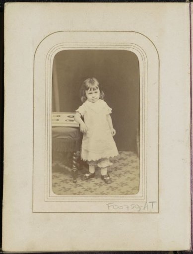 Portrait of a girl with a photo album by a chair