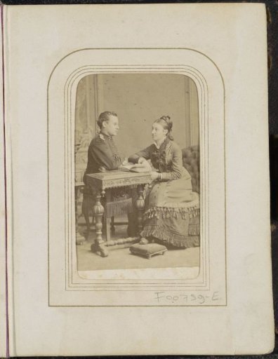 Portrait of a man and a woman at a table with a book