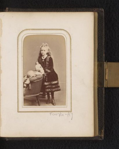 Portrait of a girl with a doll and hat