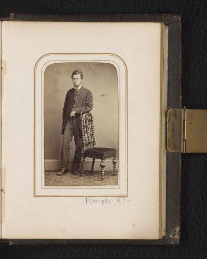Portrait of a man, standing by a chair
