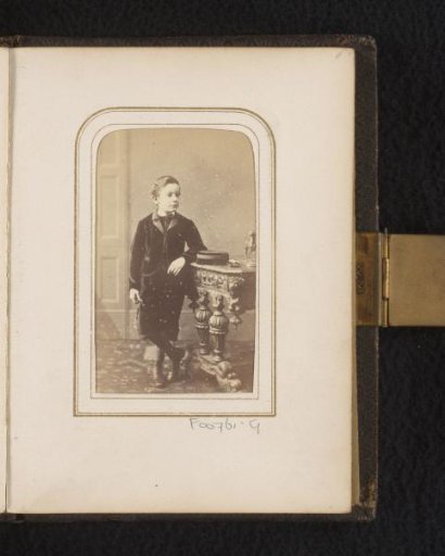 Portrait of a boy, standing by a table