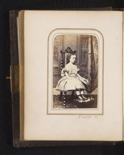 Portrait of a girl, seated with a basket and book
