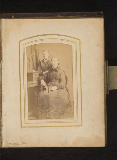 Portrait of a seated and a standing woman at a writing desk