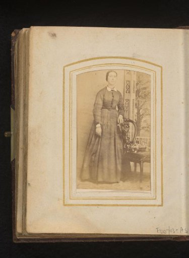 Portrait of a woman, standing by a chair