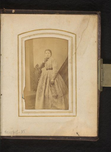 Portrait of a woman, standing by a chair