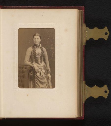 Portrait of a young woman, standing by a chair