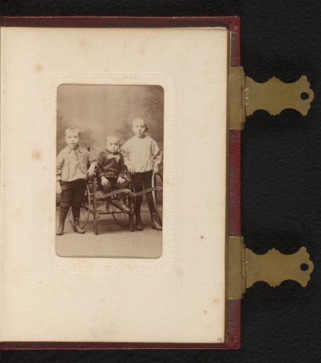 Portrait of three children, one seated in a wheeled chair