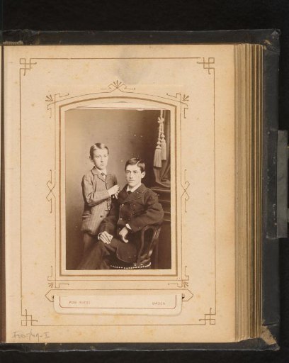 Portrait of two boys, one standing and the other sitting