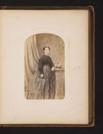 Portrait of a woman standing by a pedestal