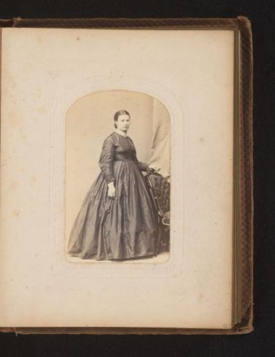 Portrait of a woman standing by a chair