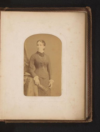 Portrait of a standing woman holding a fan